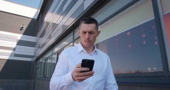 Mature Ceo Executive Using Smartphone and Walking Downtown