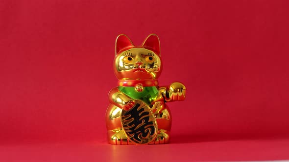 Golden Maneki-neko cat waving with paw