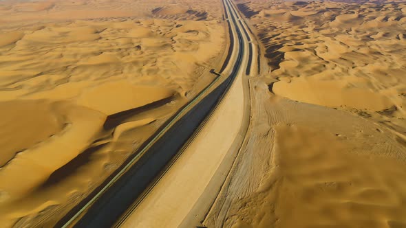 Aerial view above of train rail crossing vast desert, U.A.E.