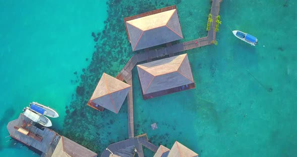 Aerial flight over clear turqoise water and floating village in Mabul, Malaysia