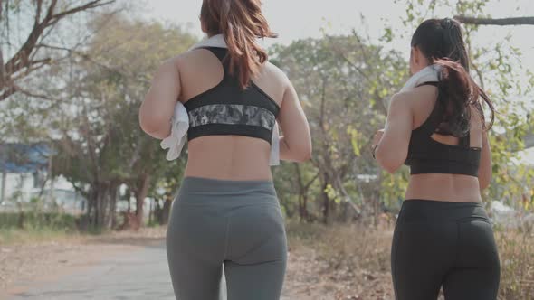 Back view of two woman running outdoor together in the morning
