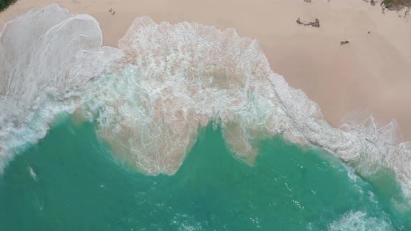 Aerial View of Blue Ocean Waves Crashing at White Sand Beach