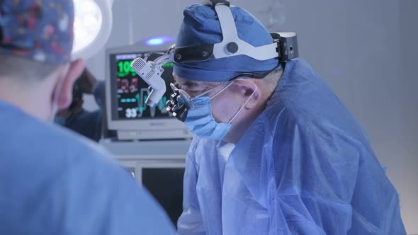 The Surgeon Wearing Special Optics Oversees the Operation
