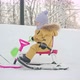 A kid rides a snowcat sled with a shovel toy in his hand along a snowy path in a city park. - VideoHive Item for Sale