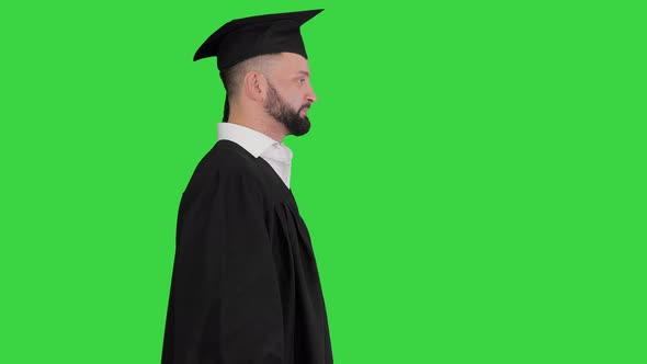 Happy Graduate Male Student Walking on a Green Screen, Chroma Key.