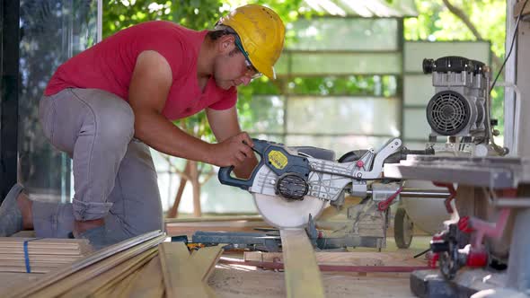 Carpenter cutting wood for house construction