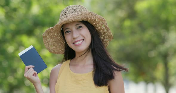 Happy woman hold passport and smiling at outdoor