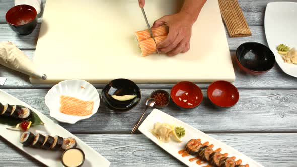 Hand with Knife Cutting Sushi