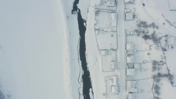 Aerial View of the River with Ice in the Middle of the Village