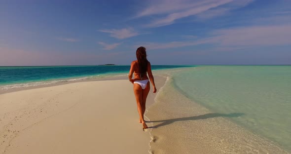 Young Smiling Lady on Vacation Enjoying Life at The Beach on Clean White Sand and Blue