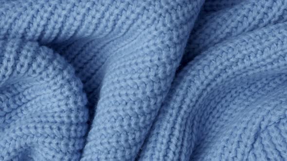 Texture of a Warm Cozy Knitted Scarf Folded Into Picturesque Folds, Blue, Top View, Selective Focus