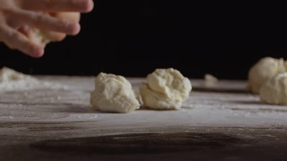 Male Hands Divide Baking Dough Into Shares on a Board Sprinkled with Flour