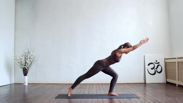 Young and fit woman practicing yoga indoor in the class.