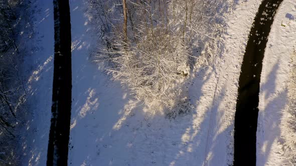 Aerial winter look-up shot from a tight curved street up to a snowy landscape under a blue sky - bea