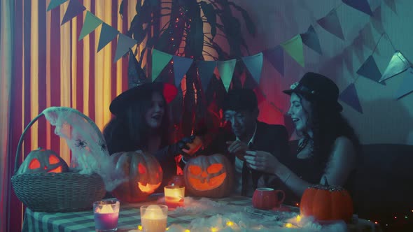 A Group of Friends Celebrating Halloween Laughing and Chatting Together