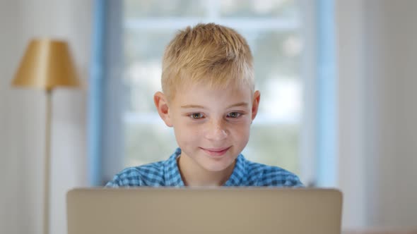 Portrait of Caucasian Preteen Boy Using Laptop at Home