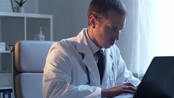 Professional medical doctor working in hospital office using computer technology.