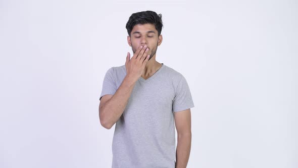 Young Handsome Bearded Indian Man Covering Mouth While Looking Guilty