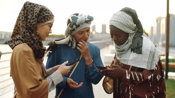 Muslim Women Using Smartphones on Walk