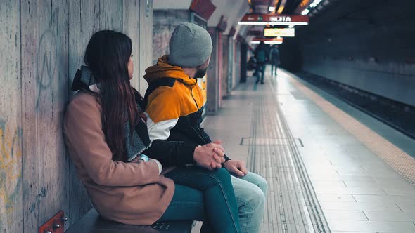 transport, metro - couple sitting on the bench at station waiting for the subway