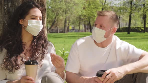 Man and Woman in Face Masks Having Conversation in Park