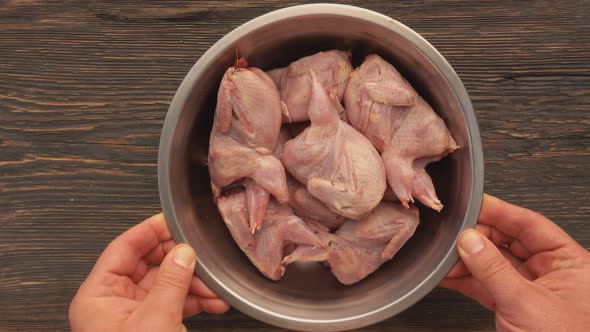 Close-up Top View of Hands Placing a Bowl Full of Raw Quails on the Table