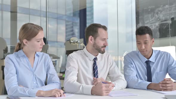 Middle Aged Businessman Having Discussion on Documents with His Assistants