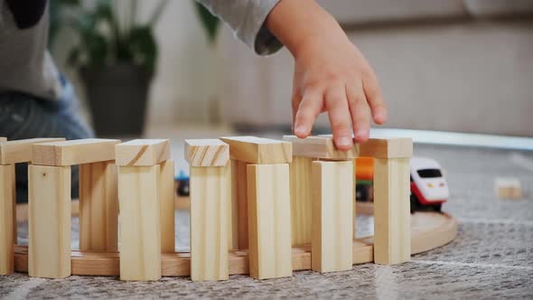 Child Play Build Wooden Railroad Starts an Electronic Steam Locomotive Sitting on the Floor at Home