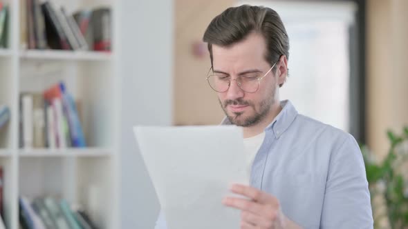 Portrait of Man in Glasses Reading Documents