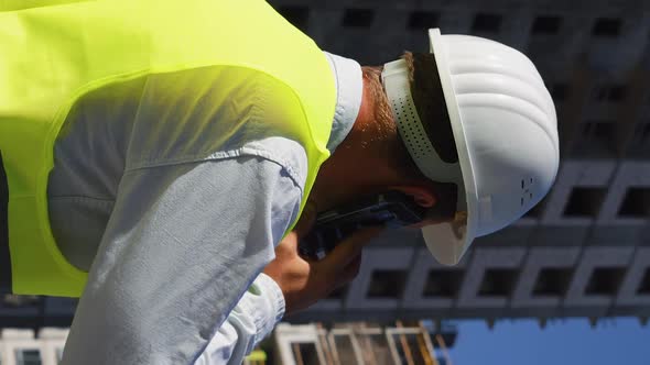 Vertical Screen Civil Engineer at Construction Site Talking on Phone