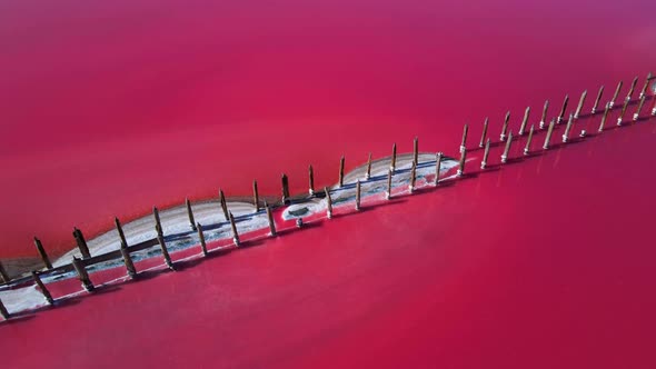 Aerial Top Cinematic View Over Beautiful Pink Salt Lake with Deep Colorful Calm Water Surface and