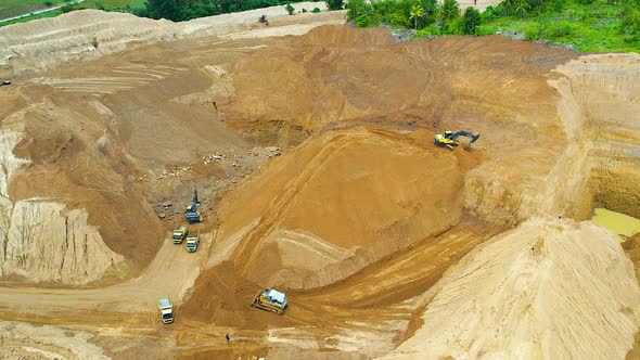 Aerial view of Work of trucks and the excavator in an open pit on gold mining.