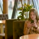 Young girl using smartphones sitting in cafe texting hanging - VideoHive Item for Sale