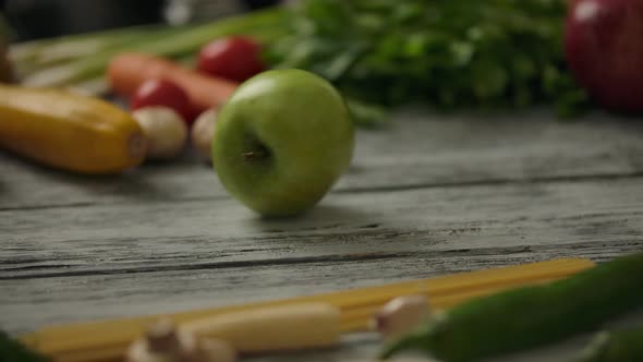 Crop Person Rolling Apple on Table