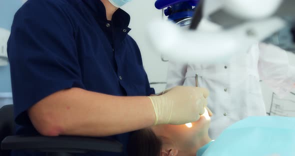 The Dentist Examines the Patient's Oral Cavity Using a Dental Mirror