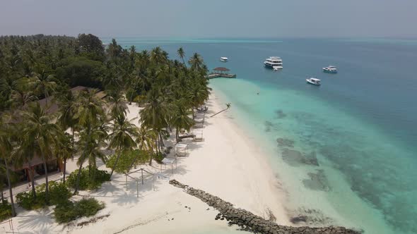 Incredible view of the beautiful Maldivian island with green trees, white sand and turquoise water,