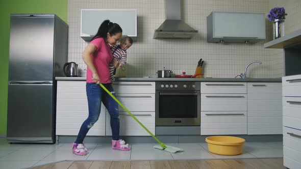 Mother Mopping the Floor and Dancing Holding Baby