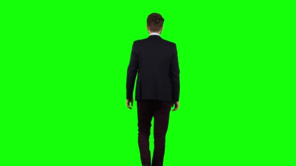 Businessman Is Going To a Meeting and Waving Greetings. Green Screen. Back View