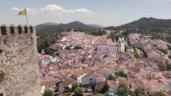 Aerial pullback from romantic village revealing Old Castle, Castelo de Vide - Portugal