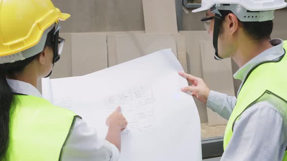 Asian colleague workers people wearing protective safety helmet and working onsite of architecture.