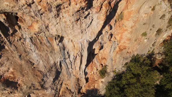 Drone Flying Out From Limestone Cliff with Rock Climber on It