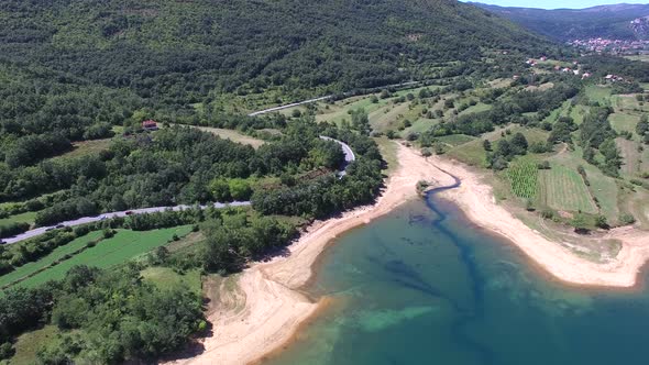 Flying above forested shore of artificial lake Peruca, Croatia