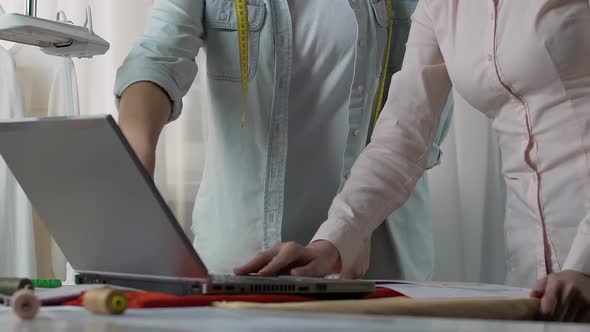 Designer and Assistant Looking Cloth Exhibition on Laptop Discussing the Shades