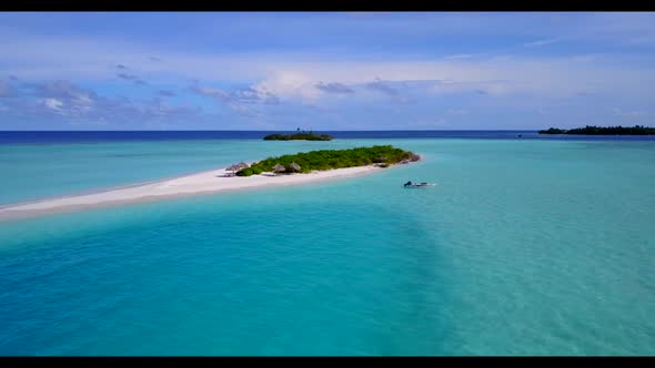 Aerial top down nature of idyllic resort beach lifestyle by shallow lagoon with white sand backgroun