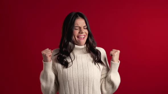 Surprised Excited Happy Latin Woman in Sweater on Red Background.