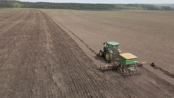 Tractor plows and cultivates the land