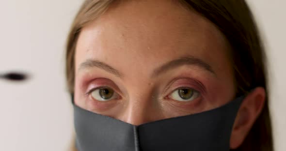 Woman in Protective Mask Applies Mascara