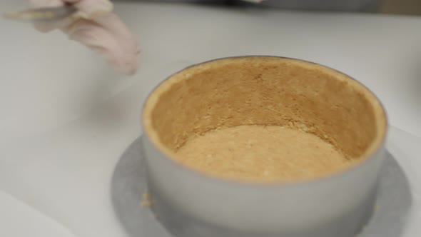 Confectioner's Hands in Gloves Cooking Base for Cheesecake in Aluminum Bake Form