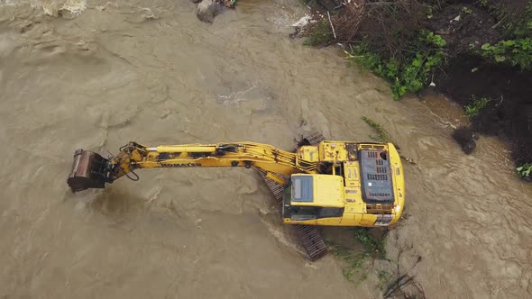 Yellow dredge Excavator working in the mountain river, scooping excavator bucket. Extracting gravel