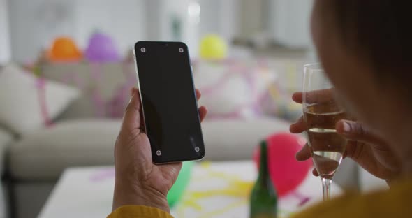 African american senior making new year's eve smartphone video call, copy space on screen